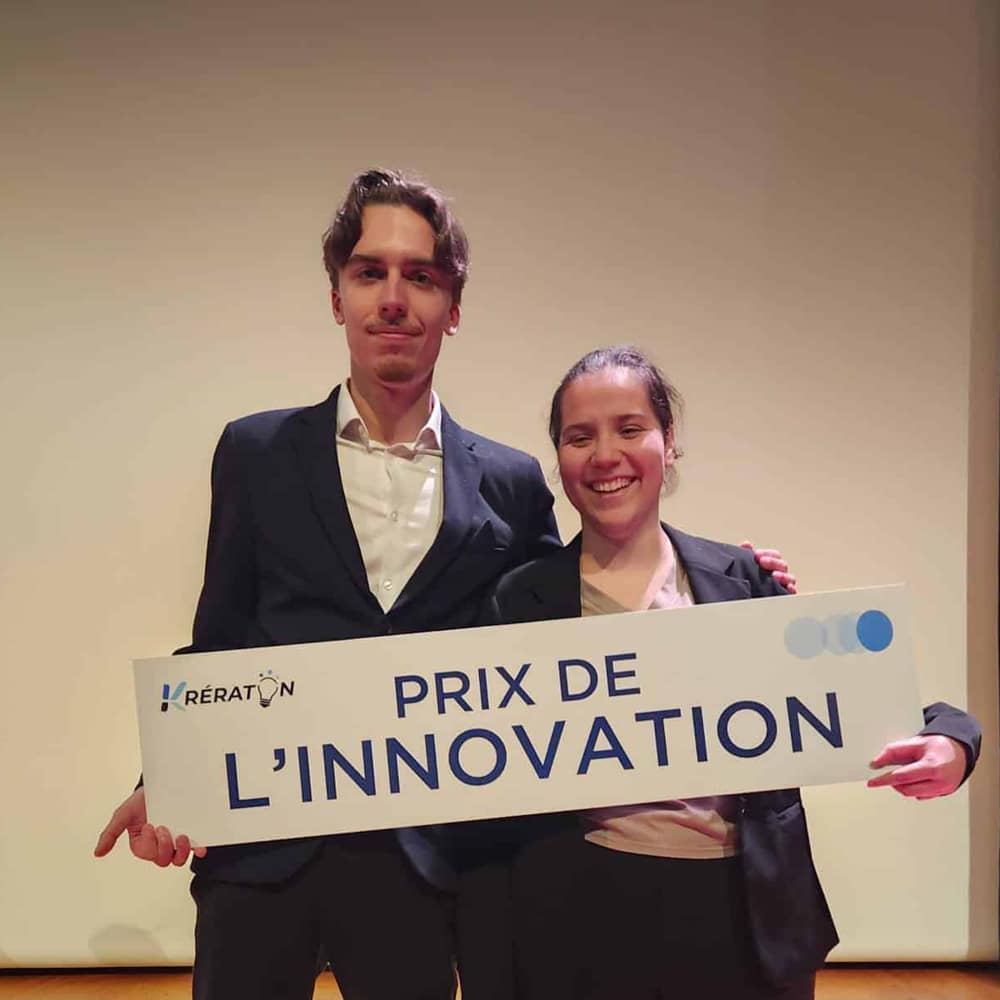 Deux personnes tiennent une banderole Prix de l'innovation