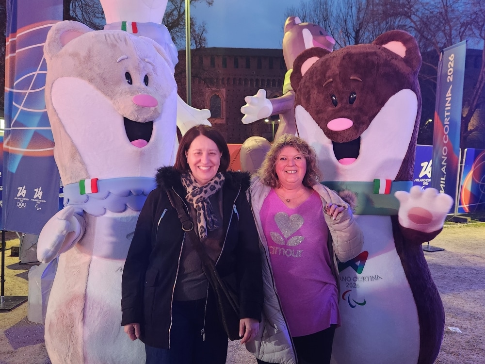 Deux accompagnatrices posent avec deux mascottes en costume lors d'un événement