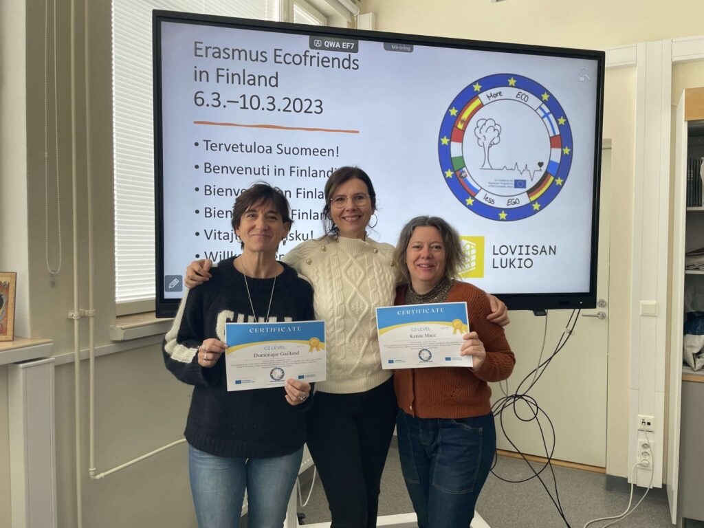 Trois enseignantes présentent leurs certificats devant l'écran du programme Erasmus Ecofriends in Finland, mars 2023